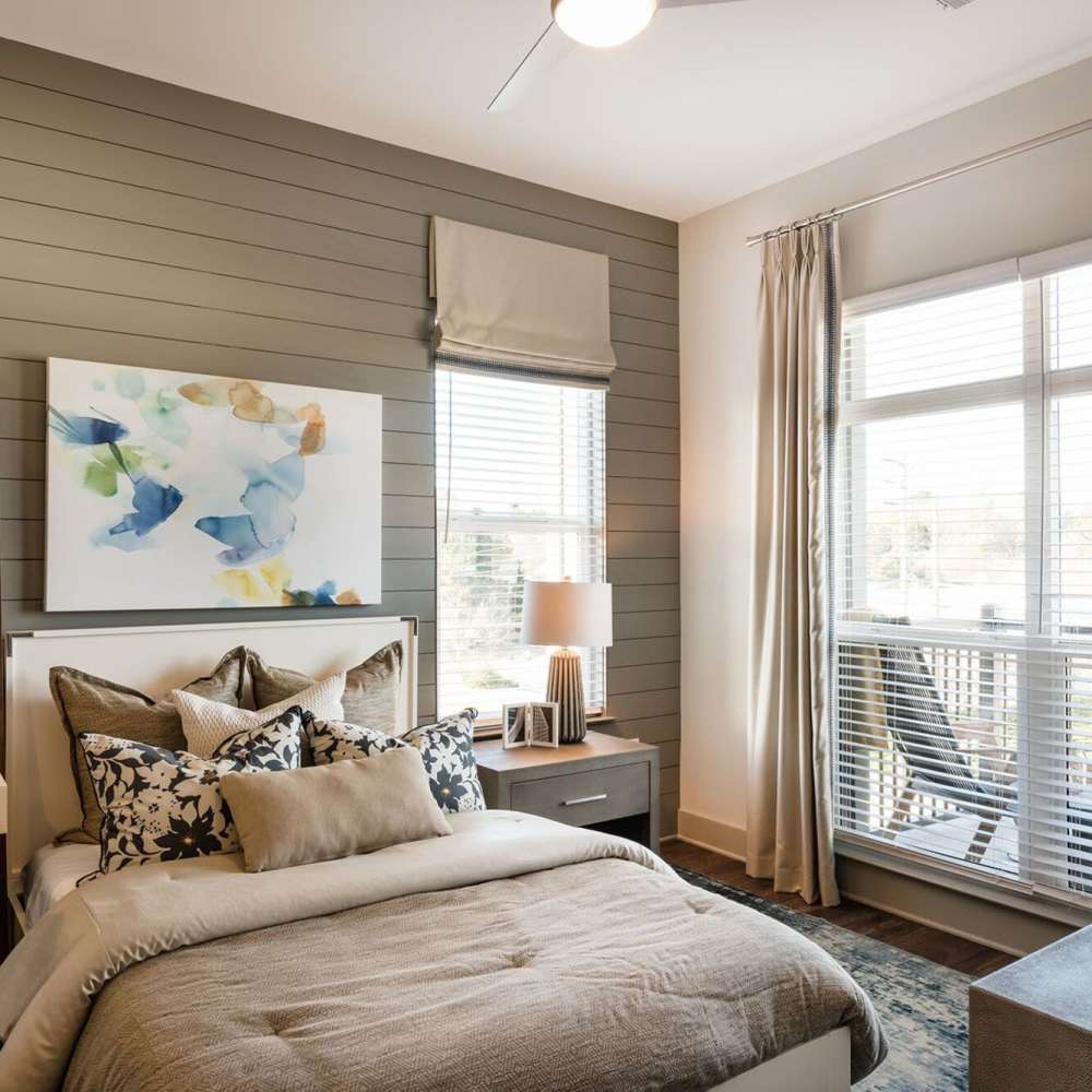 Cozy bedroom with a bed, dresser, and a bright window at Siena Suwanee Town Center in Suwanee, Georgia