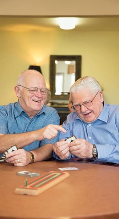 Elders play a game of cards at The Enclave at Cedar Park Senior Living in Cedar Park, Texas
