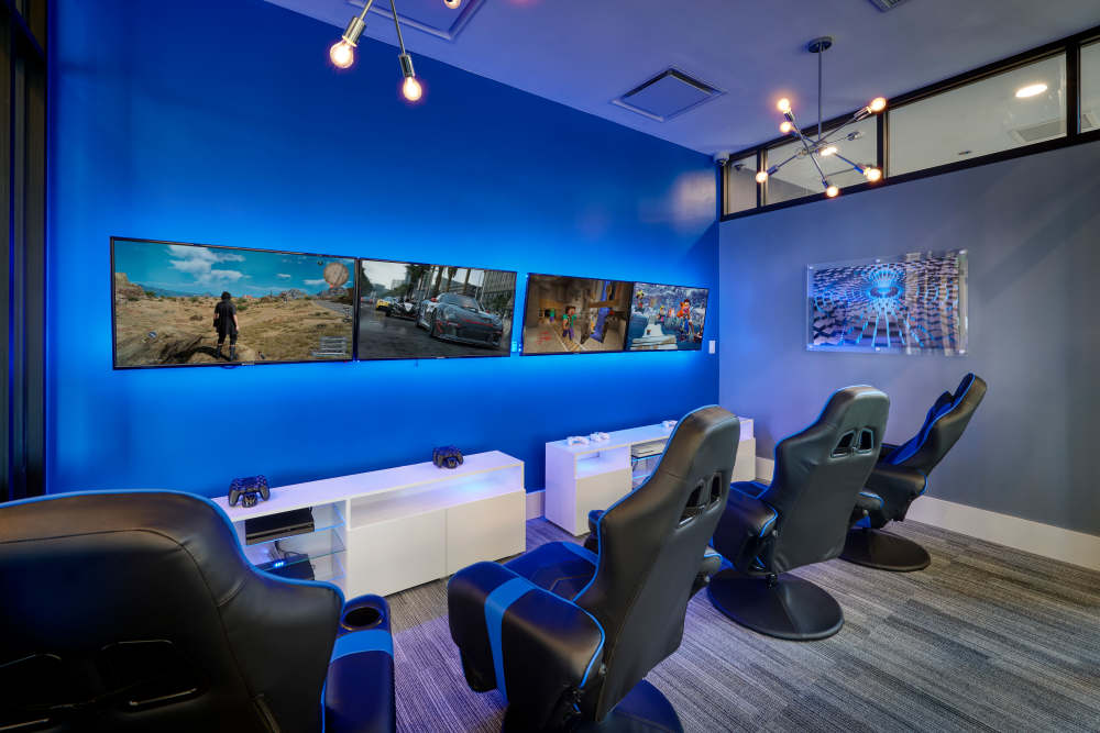 The video room, with consoles and gaming chairs, at Strata Apartments in Denver, Colorado