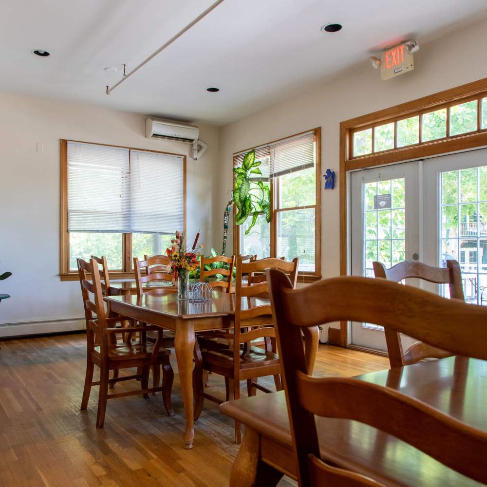 Well-furnished dining area with plants in the side at Hearth at Burroughs in Jamaica Plain, Massachusetts