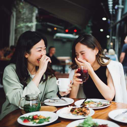 Two women sharing a laugh while having a meal near Paddock Club Apartments in Florence, Kentuckya coffee at Paddock Club Apartments in Florence, Kentucky