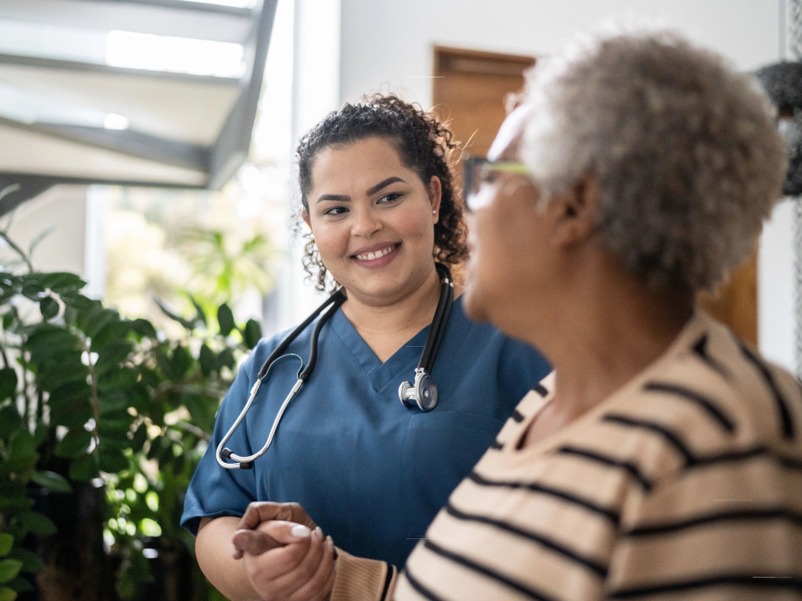 Resident walking with a nurse at Carriage Inn Huntsville in Huntsville, Texas