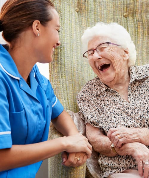 Resident talking with a caretaker outdoors at Windsor House Corporate in Girard, Ohio