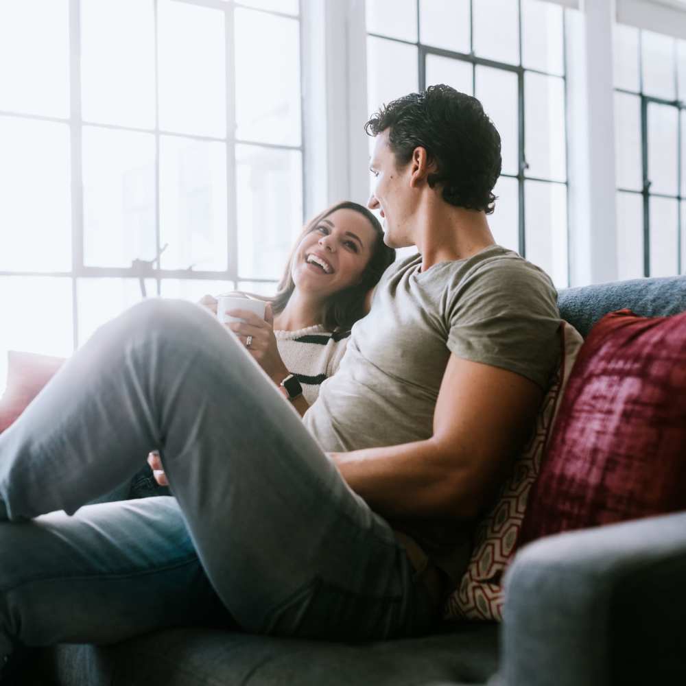 Cute couple laying on the couch relaxing together at The Ivy in Tampa, Florida