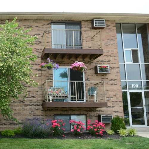 Brick exterior with flowered balconies at Indian Footprints Apartments in Harrison, Ohio