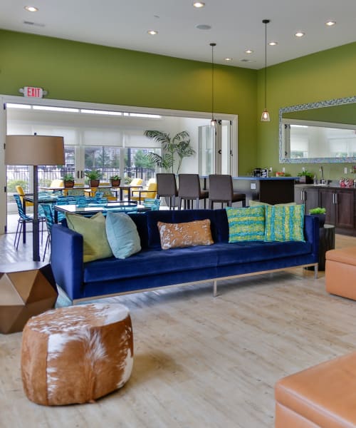 Resident lounge with a large sofa and leather benches at Arbor Brook in Murfreesboro, Tennessee