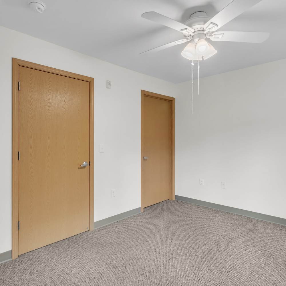 Unfurnished bedroom with carpet flooring at Residences on Main in Twin Lakes, Wisconsin