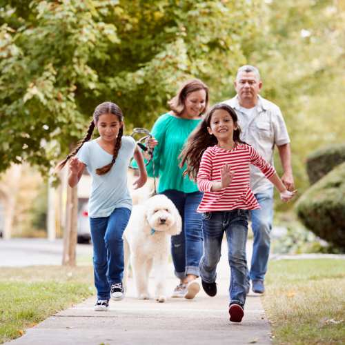 Resident family walking with their pet near park at Highland Pointe Apartments in Cottonwood Heights, Utah