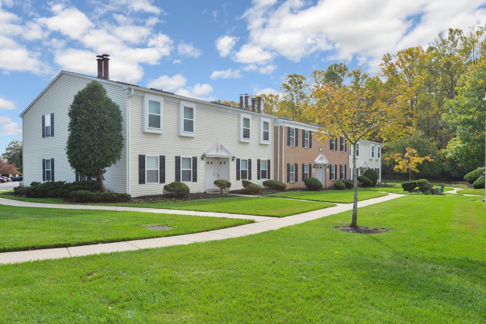 Apartment building exterior, expansive lawn, and mature trees at Tory Estates Apartment Homes in Clementon, New Jersey