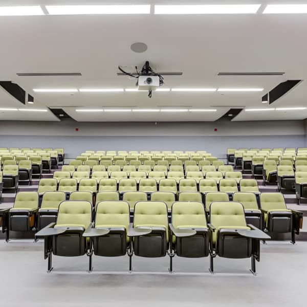 Lecture hall with green seating and projector at The Flats at East West University in Chicago, Illinois