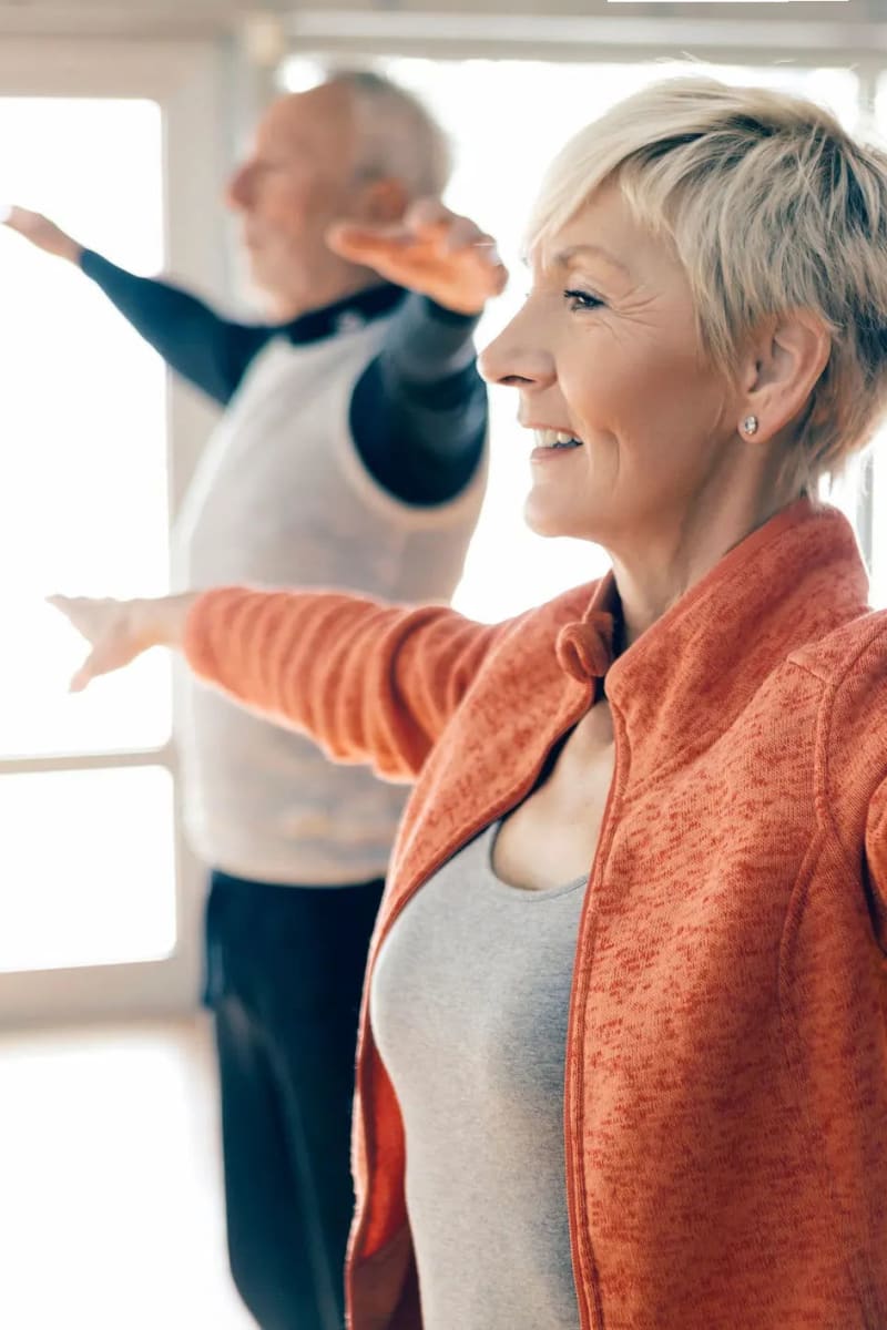 Resident couple doing yoga at Village on the Park Friendswood in Friendswood, Texas