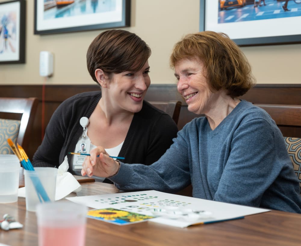 A resident and caretaker painting at Touchmark at Harwood Groves in Fargo, North Dakota