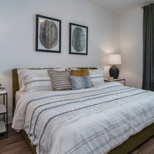 Comfortably furnished bedroom with floor-to-ceiling windows in a model home at The Atwater at Nocatee in Ponte Vedra, Florida