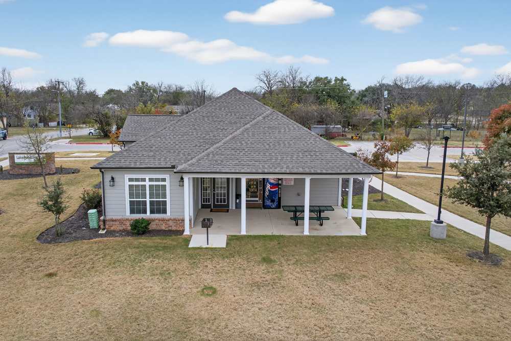 Charming community center with lush landscaping and inviting outdoor spaces at Lakewood Crossing in Granbury, Texas