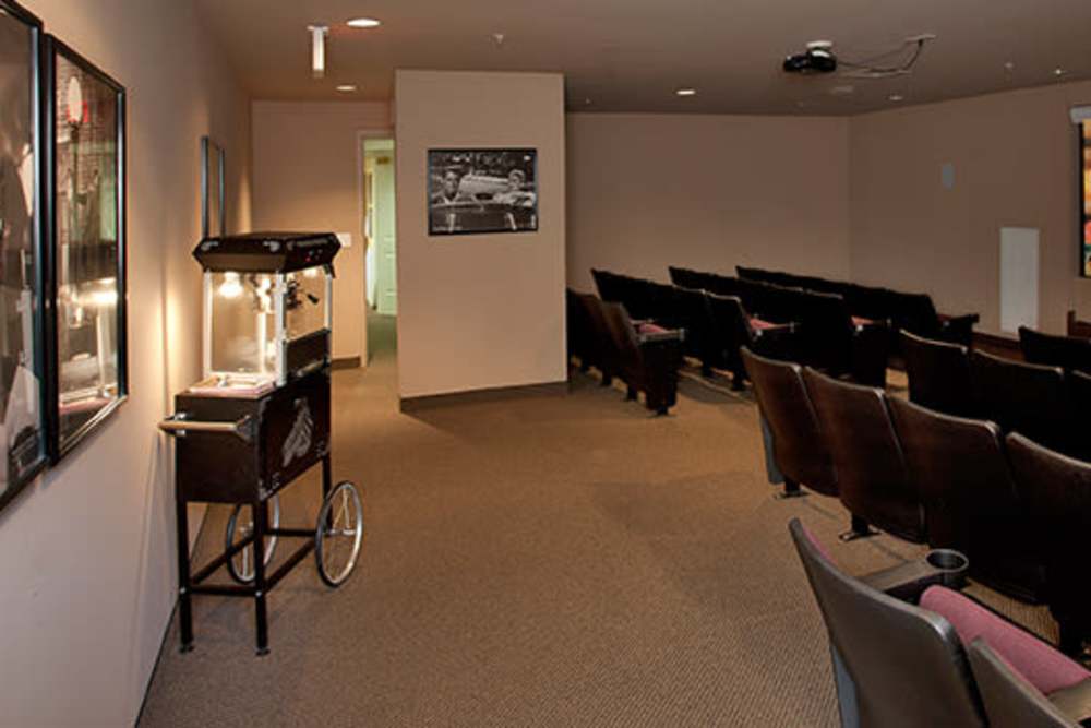 Cozy theater room with comfortable seating and vintage popcorn machine at Evergreen Senior Community in Bowie, Maryland