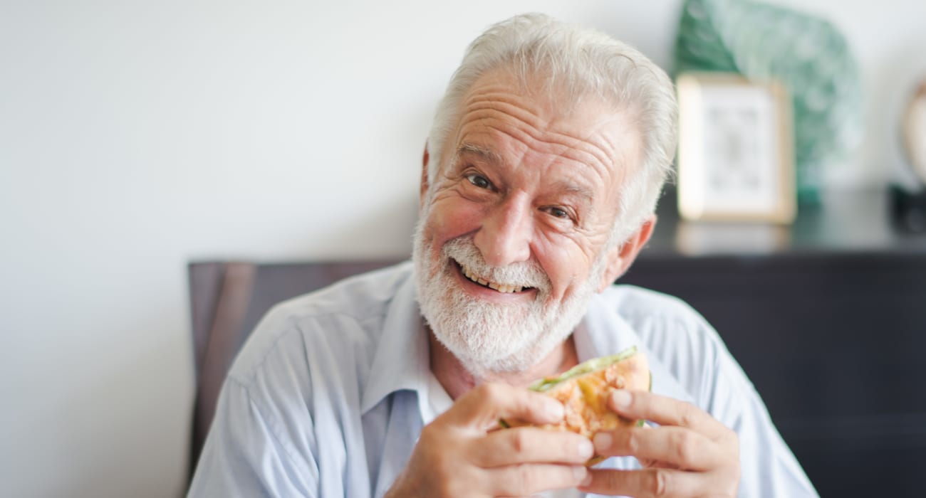 Resident enjoying a burger at Truewood by Merrill, Keller in Keller, Texas. 