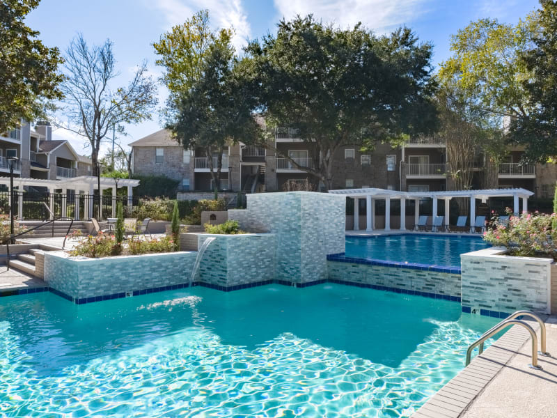 A sparkling swimming pool with a waterfall at Regency Gates in Mobile, Alabama