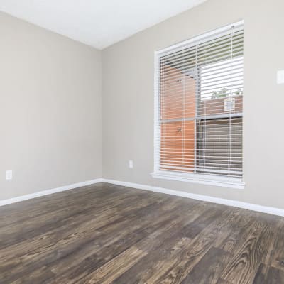 Wood-style flooring in an apartment living room at CrescentWood Apartments in Clute, Texas