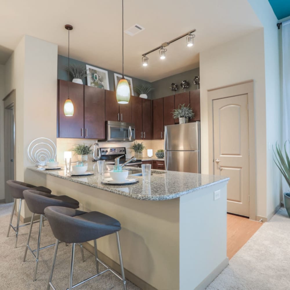 Gourmet kitchen with granite countertops, stainless-steel appliances, and pendant lighting at Imperial Lofts in Sugar Land, Texas