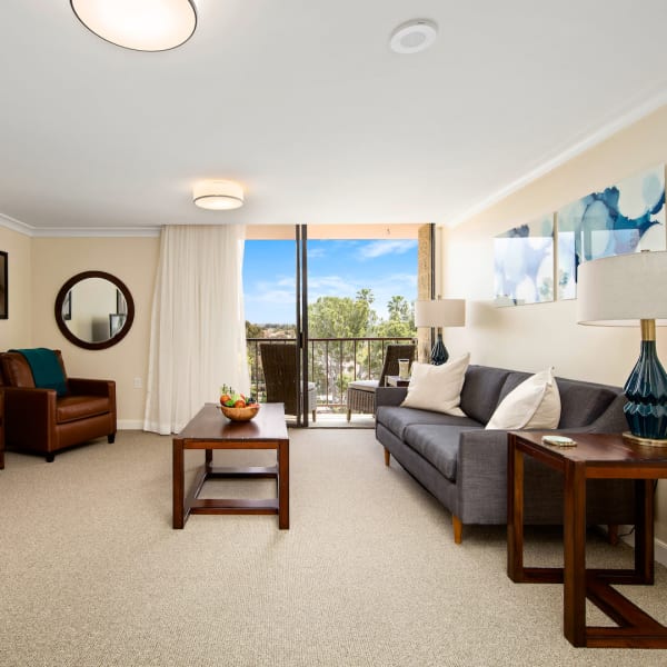 Resident living room with balcony access at Meridian at Laguna Hills in Laguna Hills, California
