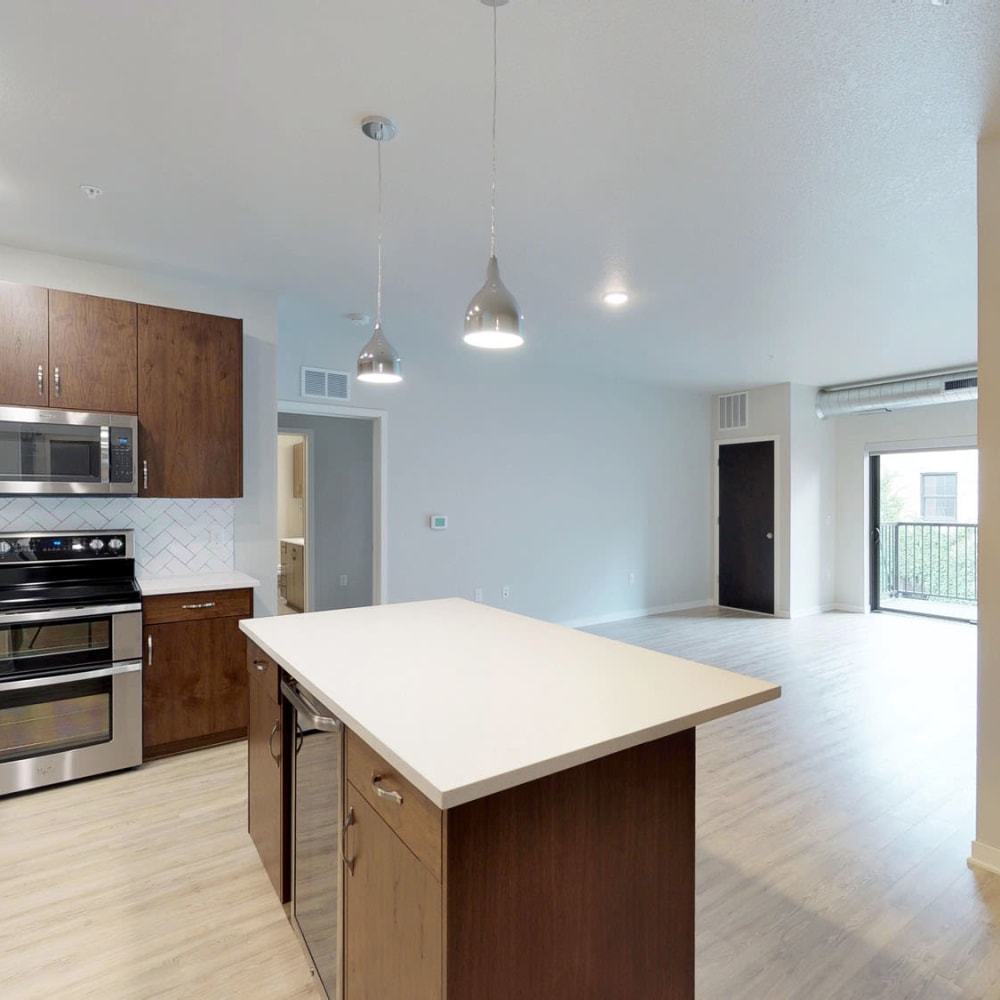 Spacious open-concept floor plan with hardwood floors and quartz countertops in the kitchen at Oaks Union Depot in St Paul, Minnesota