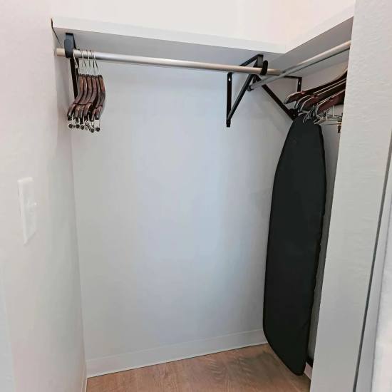 Closet with hanging space and ironing board at WaterWalk Jacksonville - Deerwood Park in Jacksonville, Florida 