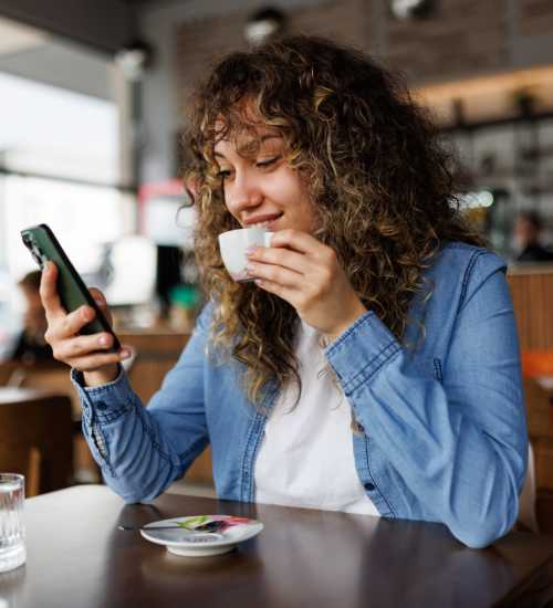 Woman having coffee at a cafe near Anchor Apartments in Freeport, Florida