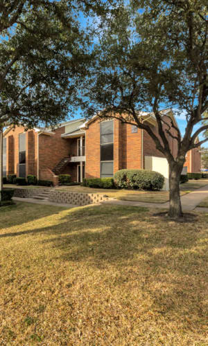 Building exterior and park-like setting at Summit Point Apartments in Mesquite, Texas