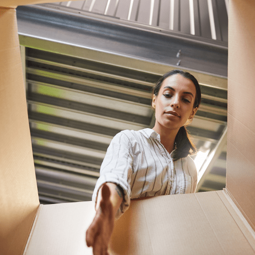 Woman reaching into box inside a climate-controlled unit at A-American Self Storage in Lancaster, California