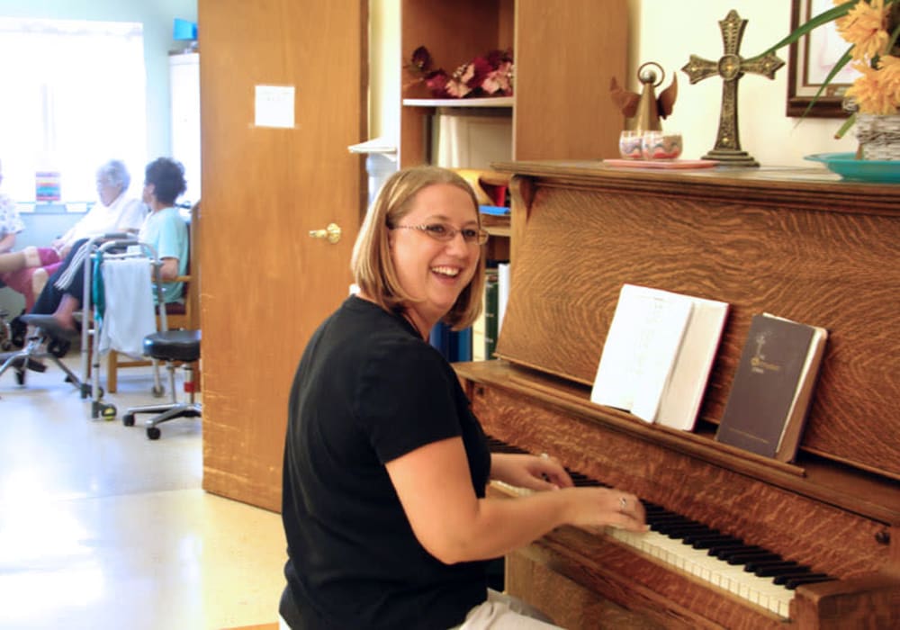 Staff member playing piano for residents at Montello Care Center in Montello, Wisconsin