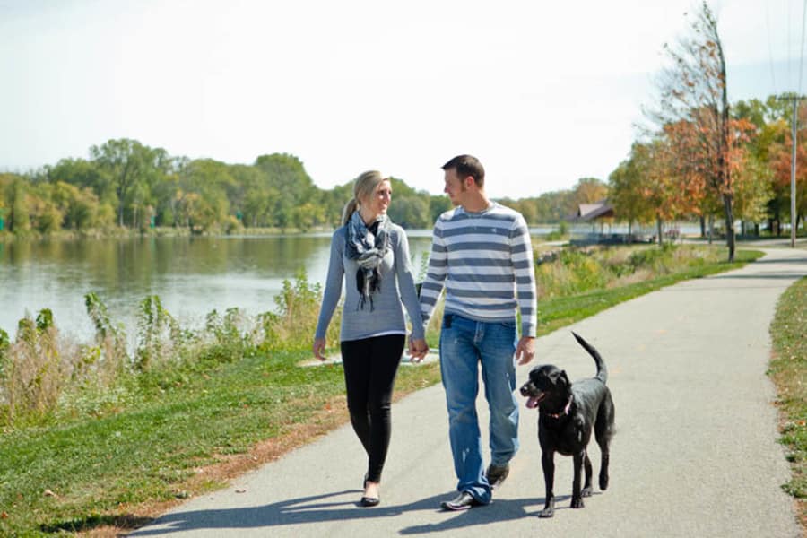 Couple walking dog near Windsor on the River in Cedar Rapids, Iowa