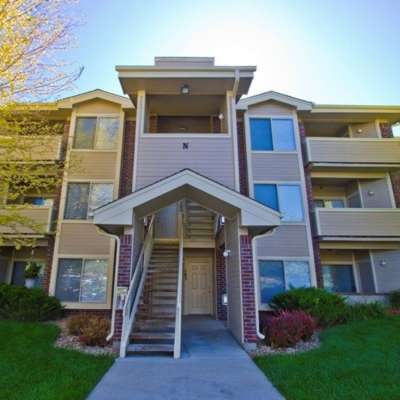 View of exterior of the apartments and green lawn at UTE Creek Apartments in Longmont, Colorado