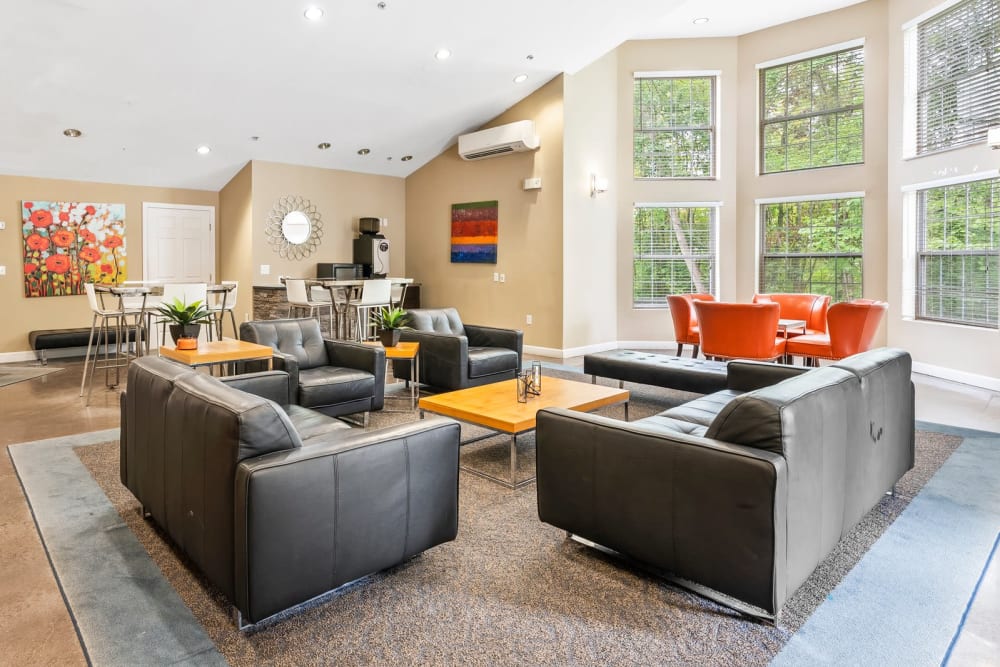 A furnished apartment living room with the kitchen in the background at The Place at Catherine's Way in Manchester, Connecticut