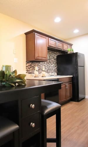 Dining area and kitchen in a model home with faux wood flooring at Buffalo Ridge in Princeton, Texas