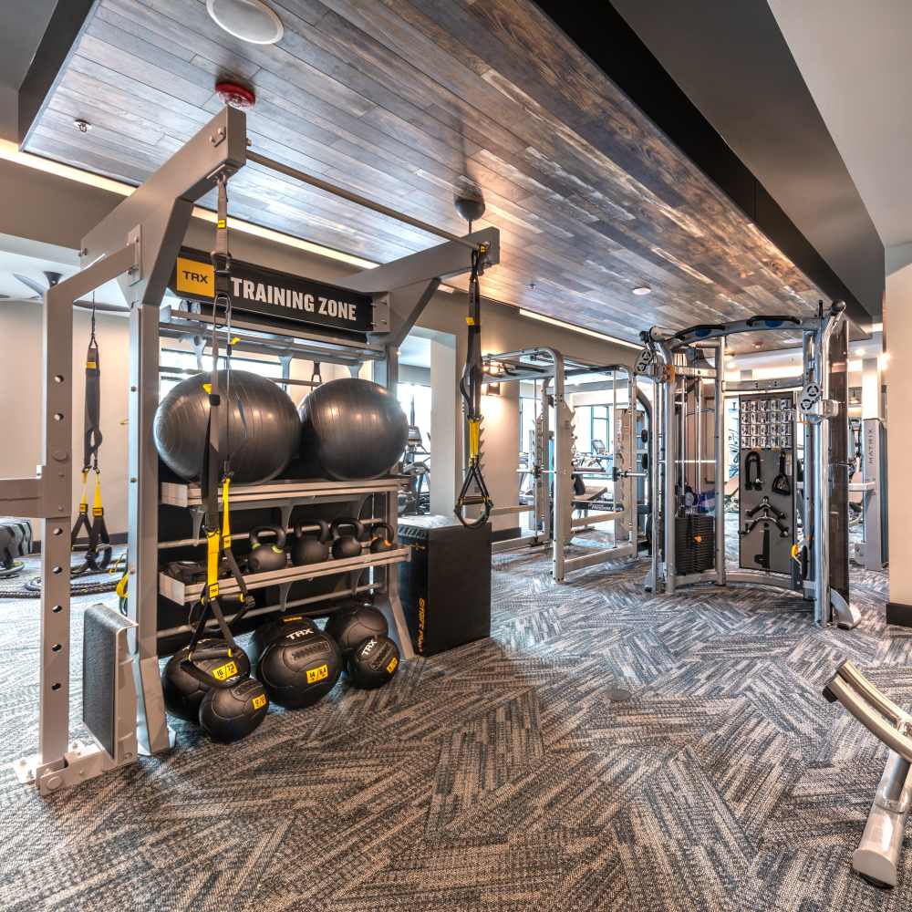 Gym area with view of a variety of weight machines and training equipment at Hall Street Flats in Dallas, Texas