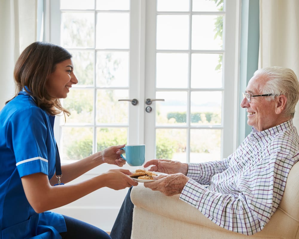 Staff offers a snack to resident in assisted living at Courtyard Estates at Cedar Pointe in Pleasant Hill, Iowa.