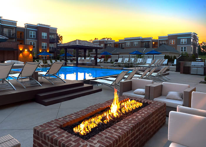 Fireplace and lounge area next to beautiful pools at Palmer House Apartment Homes in New Albany, Ohio