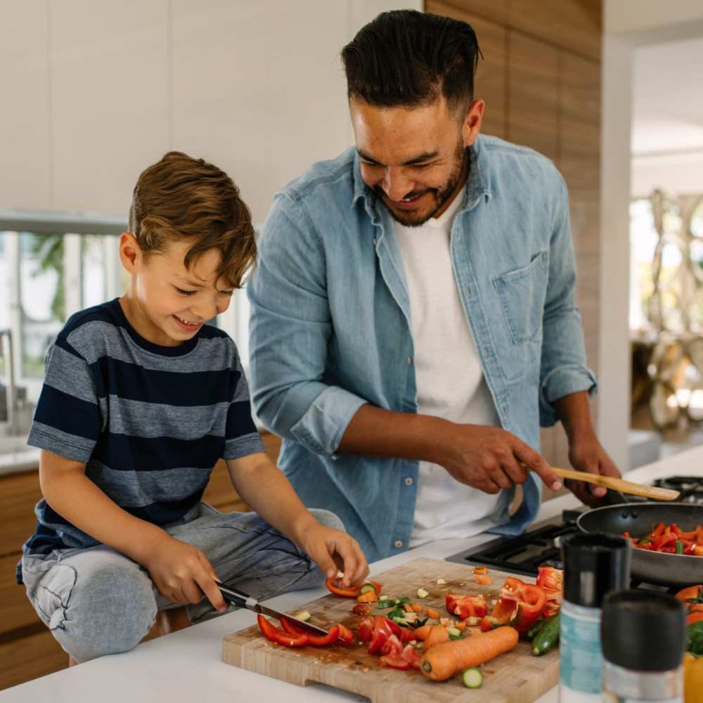Father and his kid cooking in modern kitchen at Knollview Apartments in Ovid, Michigan