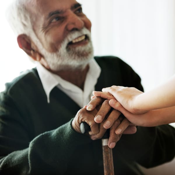 Caretaker resting their hands on a resident's at a Living Care Lifestyles community