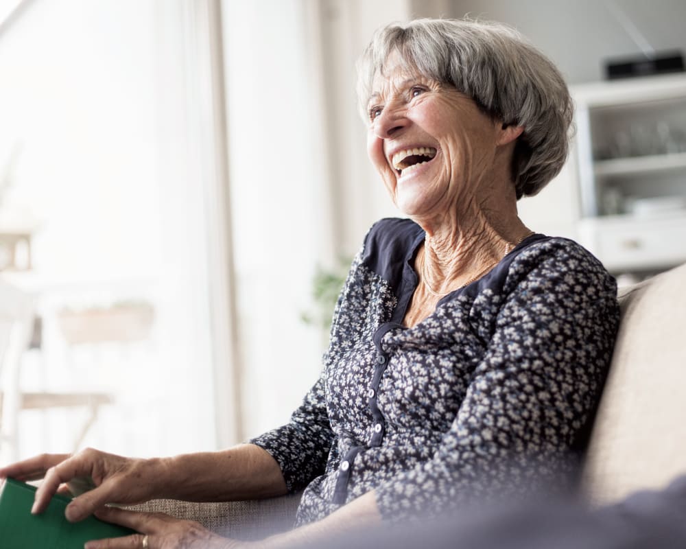 Woman sitting on the couch laughing at Anthology Senior Living in Chicago, Illinois