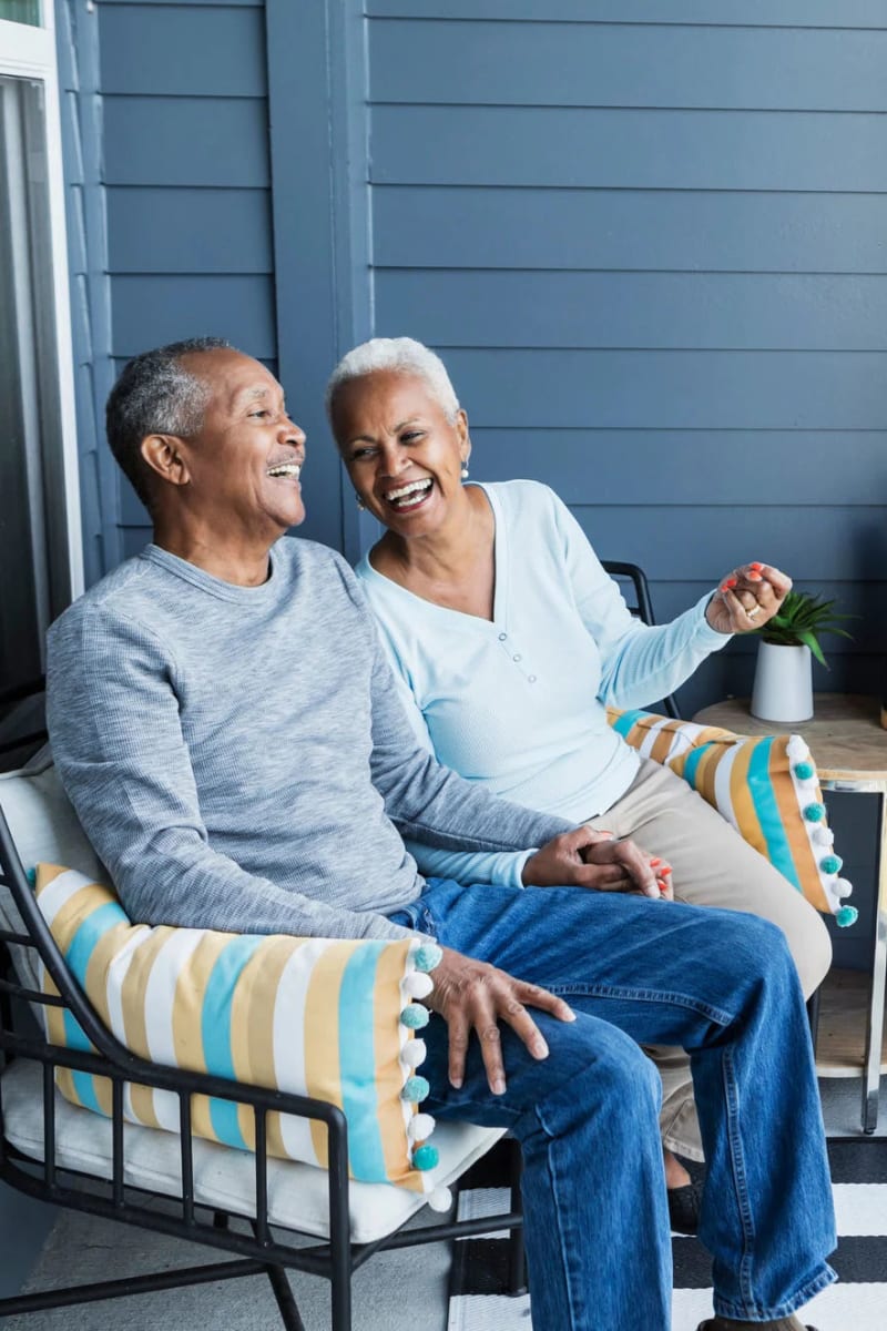 Resident couple hanging out on a porch at Carriage Inn Lake Jackson in Lake Jackson, Texas