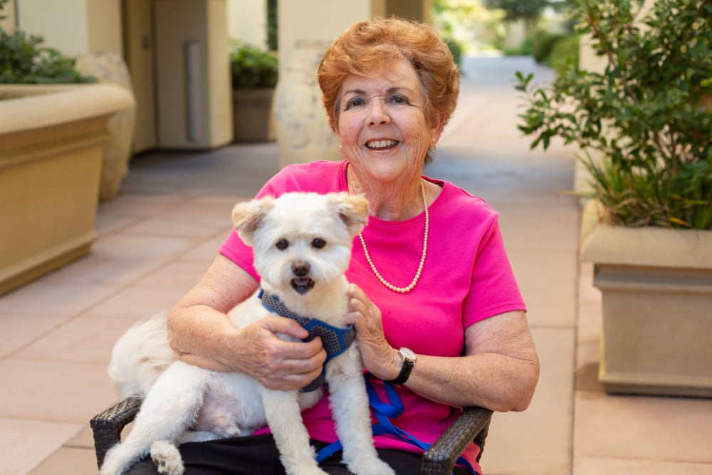 Resident with dog at Merrill Gardens at Hillsboro in Hillsboro, Oregon