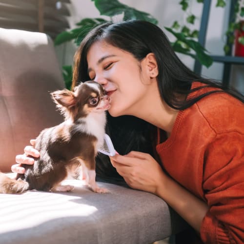 A resident and her dog in a pet-friendly apartment at The 603 in Bryan, Texas