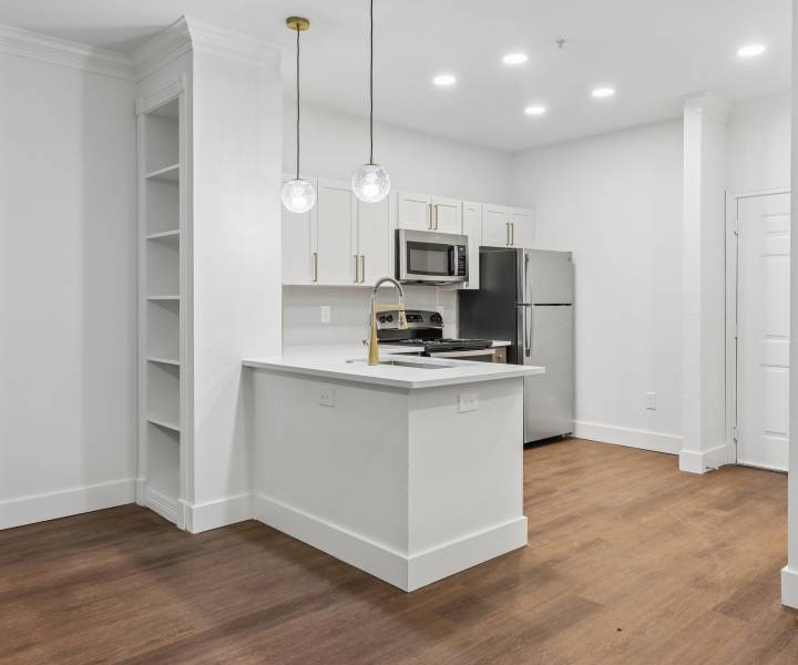 Bright living area with wood-style flooring at Calder in Round Rock, Texas 