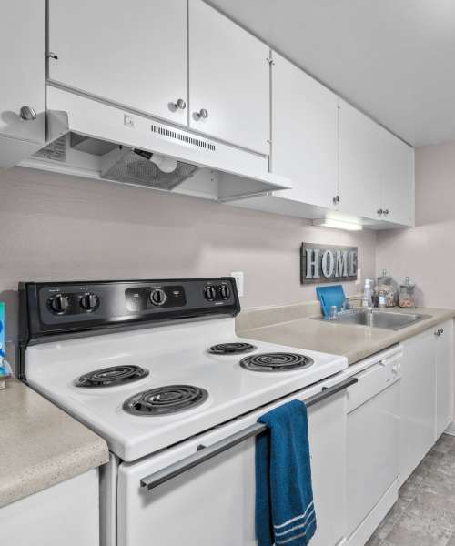 Kitchen with white appliances at West End Terrace Apartments in St. Louis, Missouri