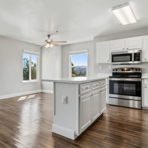 Kitchen and dining room of an apartment with upgraded finishes and tons of natural light at Quail Hill Apartments in Castro Valley, California