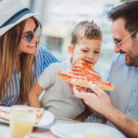 A happy family having pizza near CityView in North Kansas City, Missouri