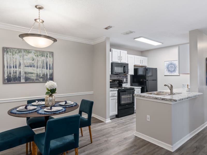 A dining room set next to the kitchen in an apartment at Regency Gates in Mobile, Alabama