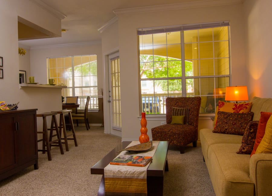 Comfortably decorated living area in the open-concept floor plan of a model home at The Lodge at River Park in Fort Worth, Texas