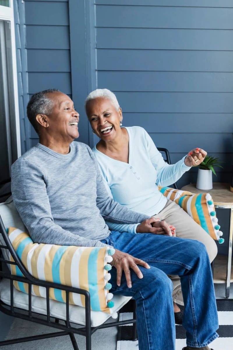Resident couple hanging out on a porch at Village on the Park Steeplechase in Houston, Texas